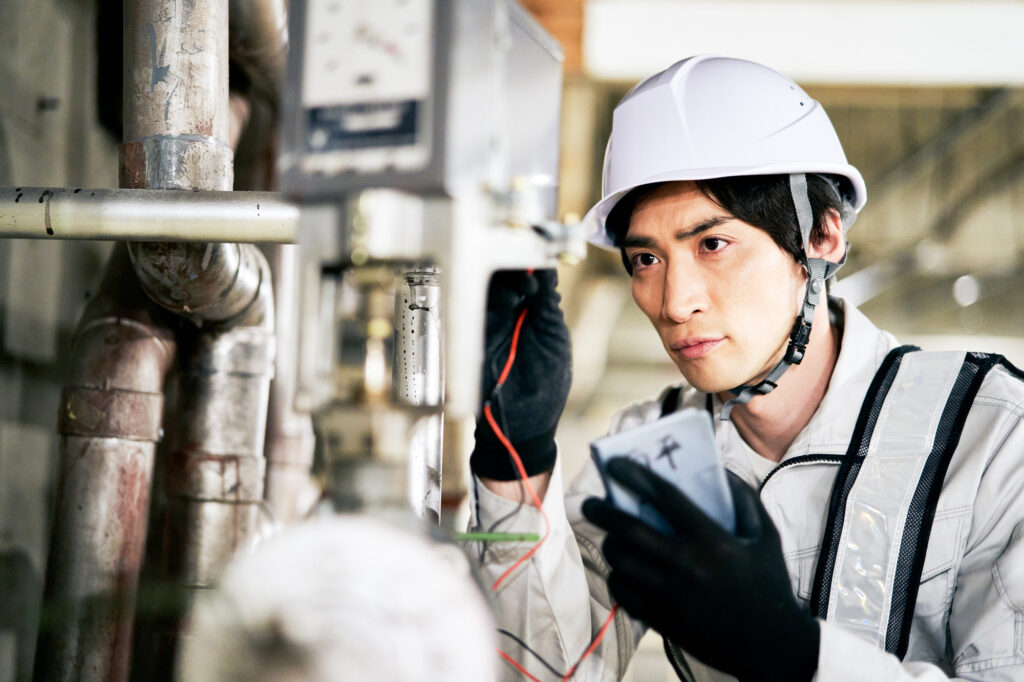企業の電気配線を整備している電気エンジニアの男性