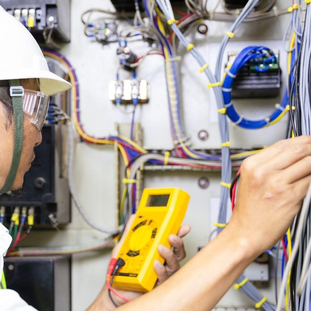 電気エンジニアのおすすめ資格5選｜取得のメリットと勉強法も紹介！のイメージ図‐テスターを使用して電圧を測っている電気エンジニアの男性